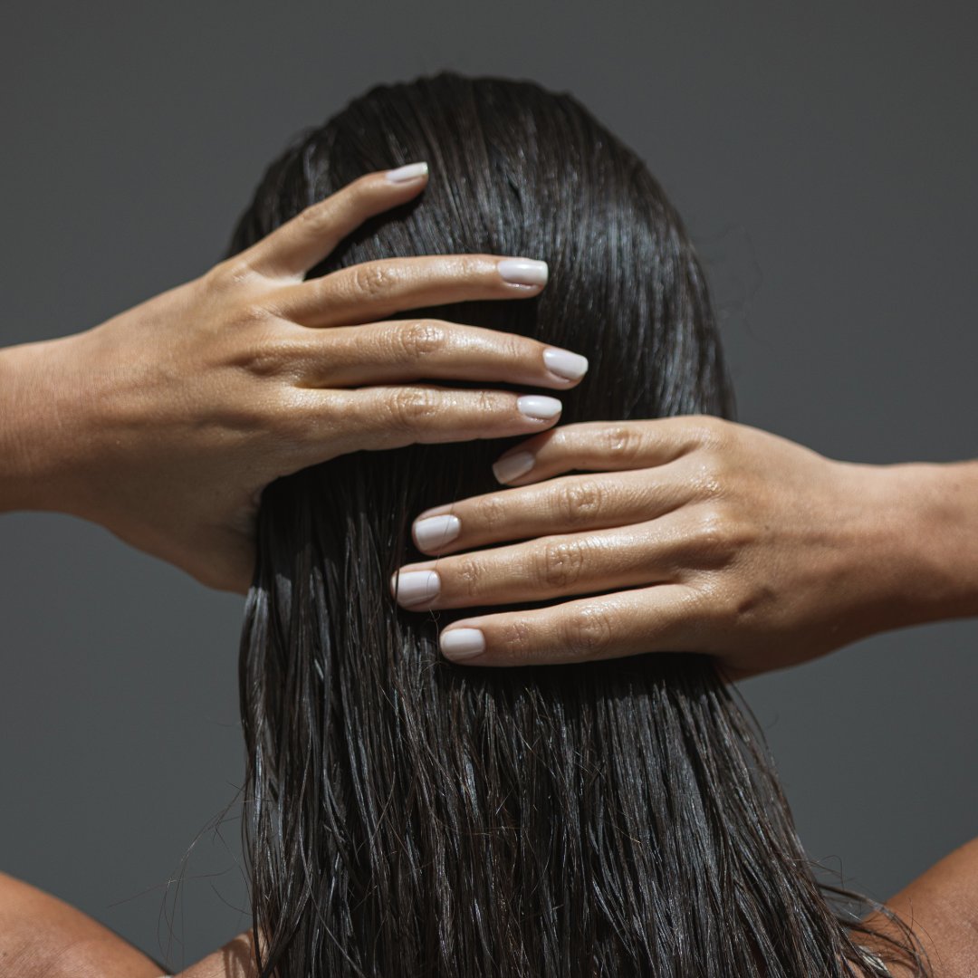Person with hands on a person's head against a gray background