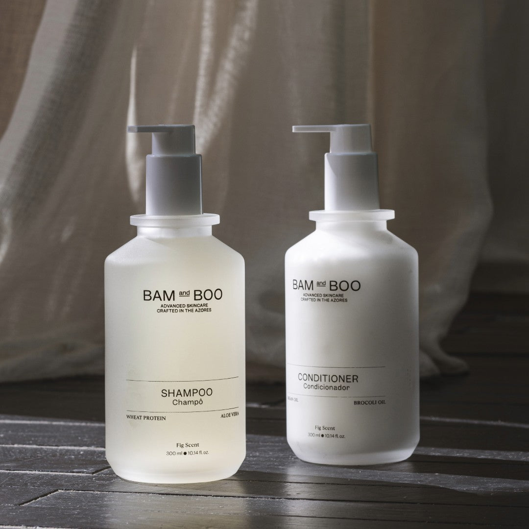 BAM & BOO shampoo and conditioner bottles on a wooden surface with a neutral background. natural premium portuguese amenities.